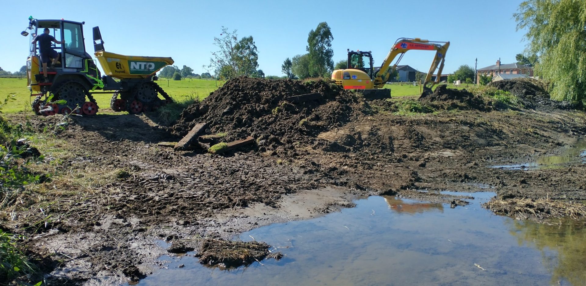 diggers behind mud and water